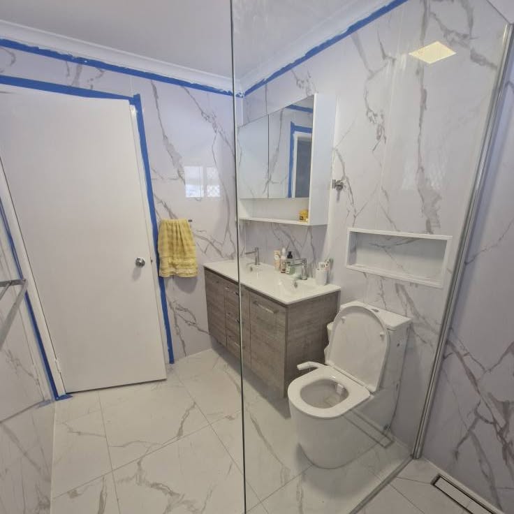 Bathroom vanity, toilet and shower screen seen from the doorway