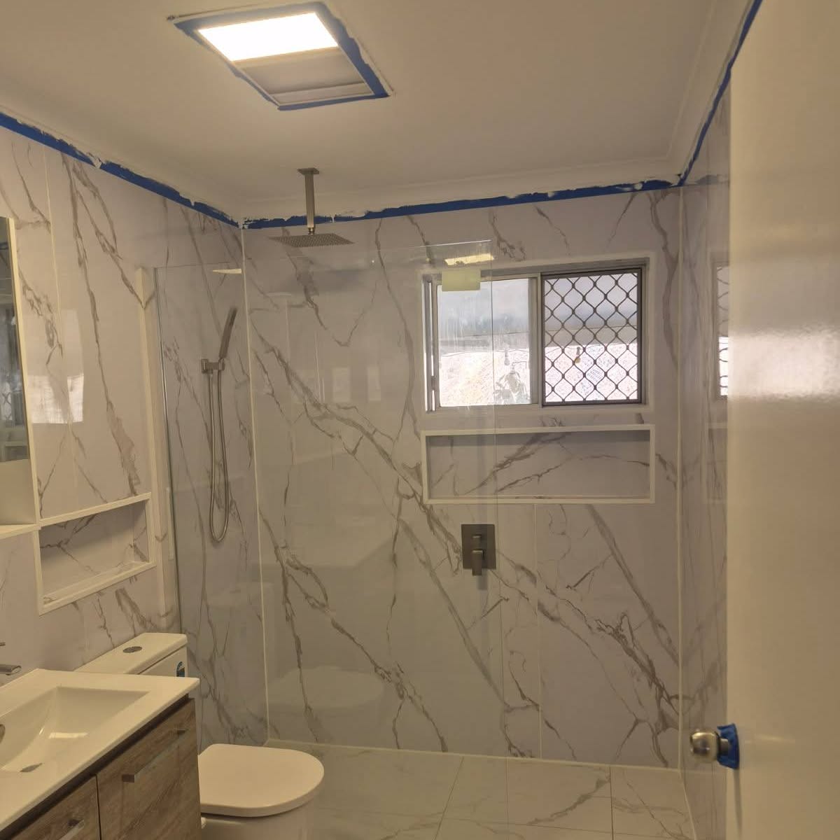 Walk-in shower with ceiling rain-head, hand shower and tiled window niche