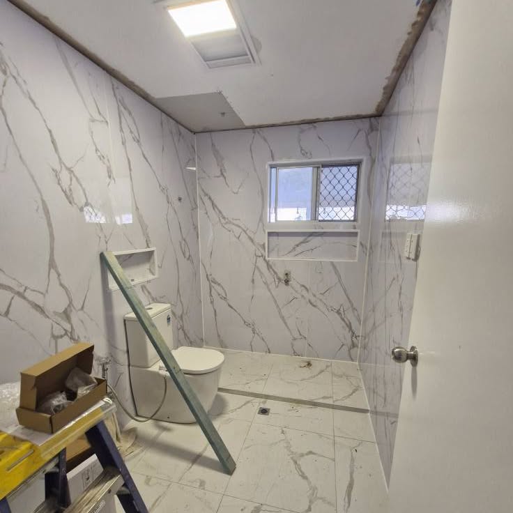 Bathroom mid-renovation showing the shower area and window niche before the screen went in